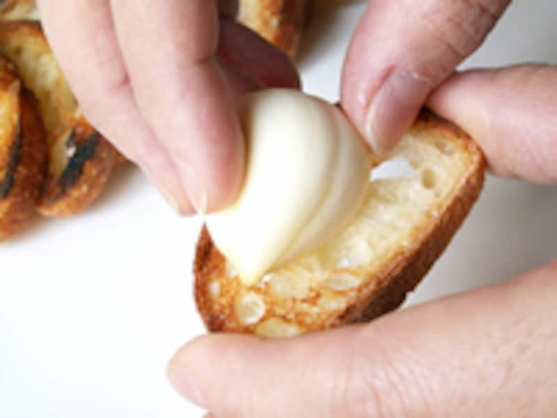 バゲットのスライスにニンニクの切り口を擦り付けます