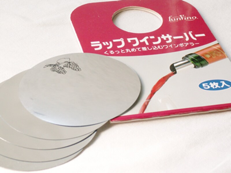 厚紙の包装の隣に広げられた銀色の円形シート