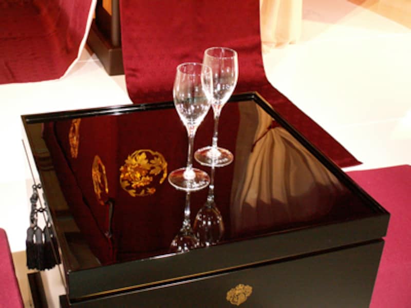 漆塗りの表面がつややかな深い漆黒の小卓にシャンパーニュ用フルートグラスが2脚置かれている