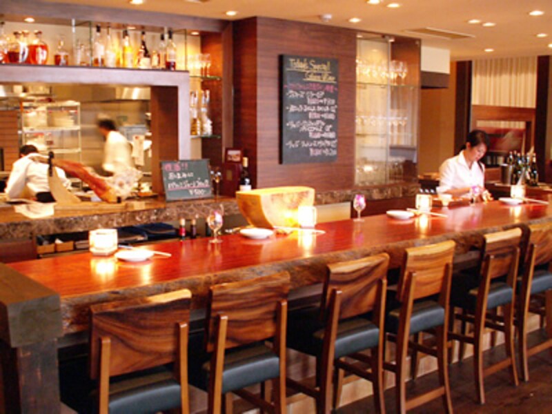 箸や皿がセットされたカウンターの向こうと厨房でスタッフが立ち働く