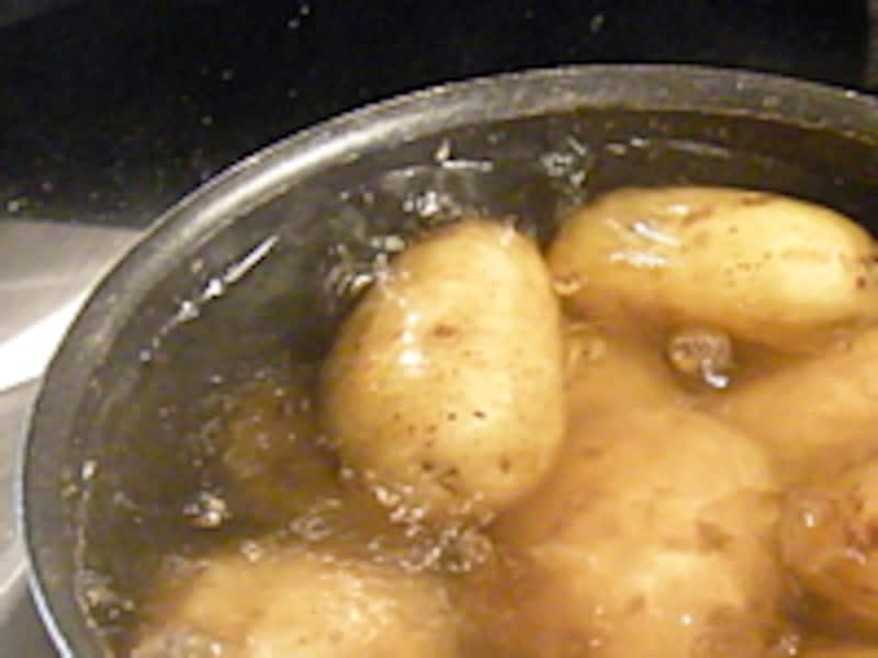 ジャガイモが鍋の中で沸騰する湯に浸かっています