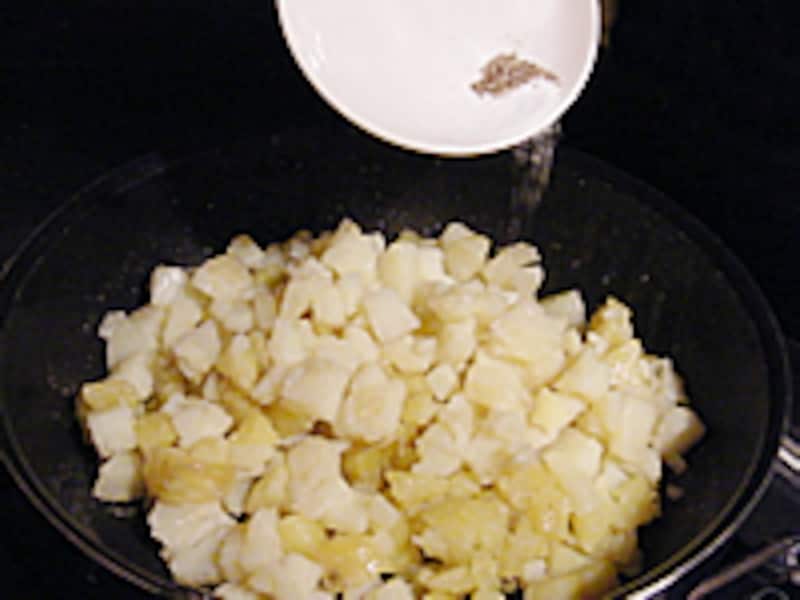 ジャガイモに塩・コショウをふりかけています