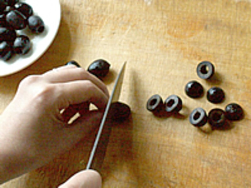 黒オリーヴを2つに輪切りにしているようす