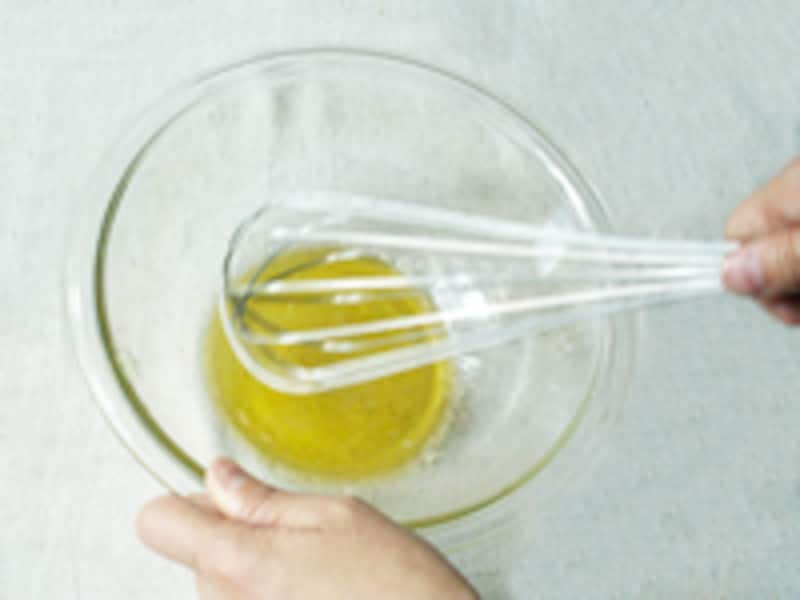 ガラスボウルの中でドレッシングをかき混ぜています