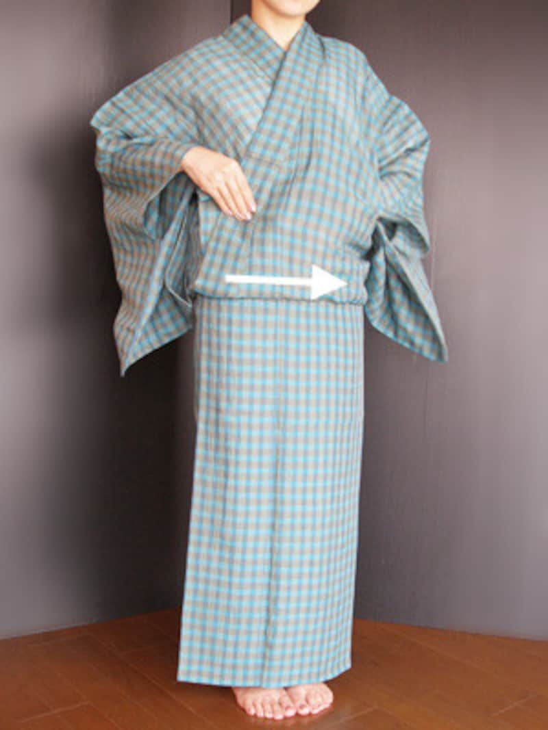 衣着付け17：衿が崩れぬよう右手で押さえながら、身八つ口から左手を入れ、前のおはしょりの中に手を入れて、衿の所から脇へ整えていきます