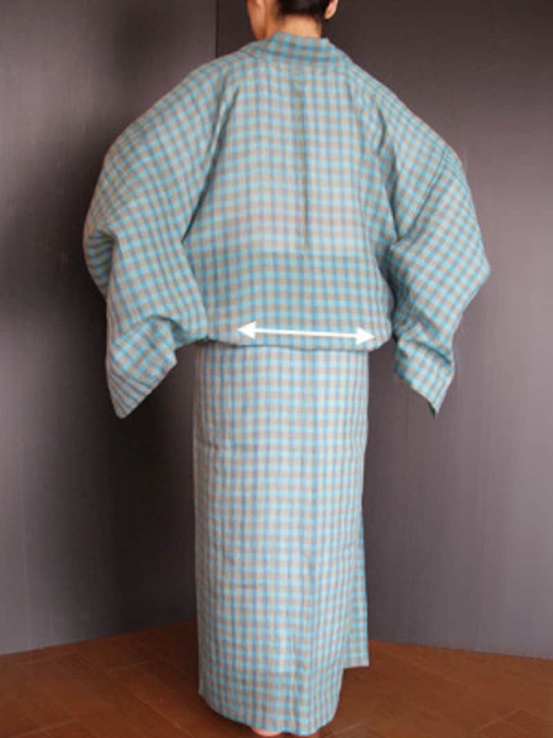 衣着付け13：後ろ側に手をまわし、後ろのおはしょりの中に手を入れて、中央から両脇に向かって整えていく