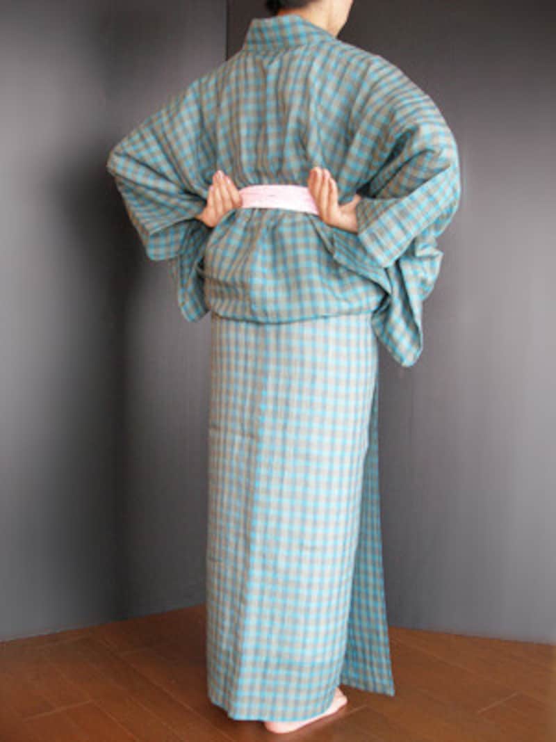 浴衣着付け21：まず後ろをきれいに整えましょう。両脇の身八つ口に親指を入れ……