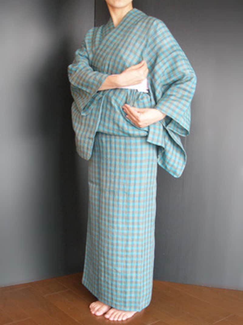 浴衣着付け25：片方の手で胸紐の上部のたるみをつまみ、もう片方の手で胸紐の下部のたるみを引きながら、タックをとって後ろ側に折り、すっきり整えます