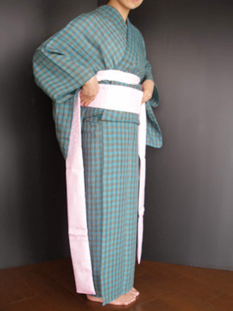 浴衣着付け29：両手で伊達締めを持って当て、伊達締めの下端でおはしょりを引き上げるように整えながら……