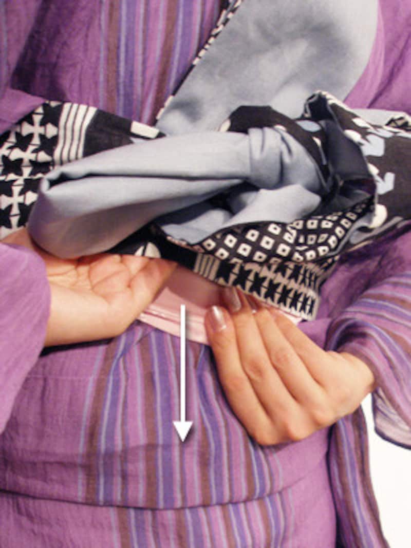 浴衣の着崩れ直し方1.帯に手を差し込み、伊達締めを下に引きます。帯がゆるいときは、ここにプチタオルを入れておくと良いでしょう。