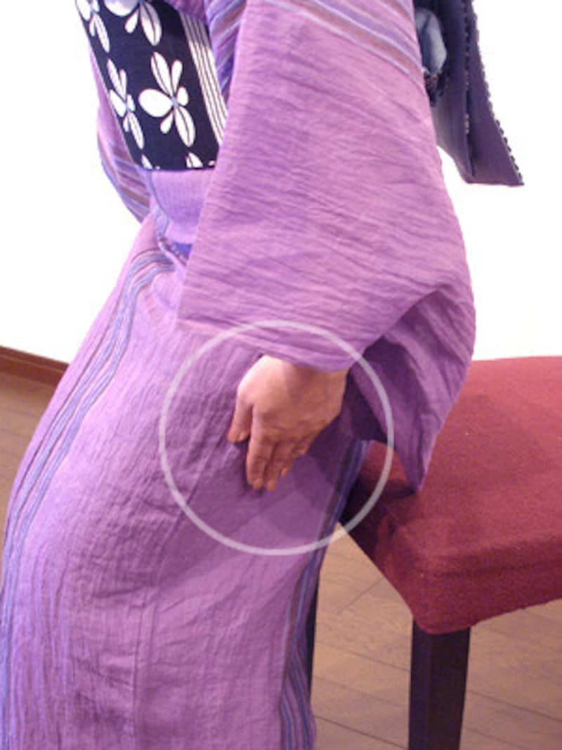 浴衣の着崩れを防ぐ座り方…太ももの両サイドから後ろに手を滑らせ、左右のもたつきを内側に折り込みながら座ります。