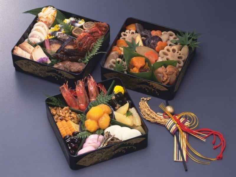 福が重なるようにとの思いを込めて、おせち料理を重箱へ