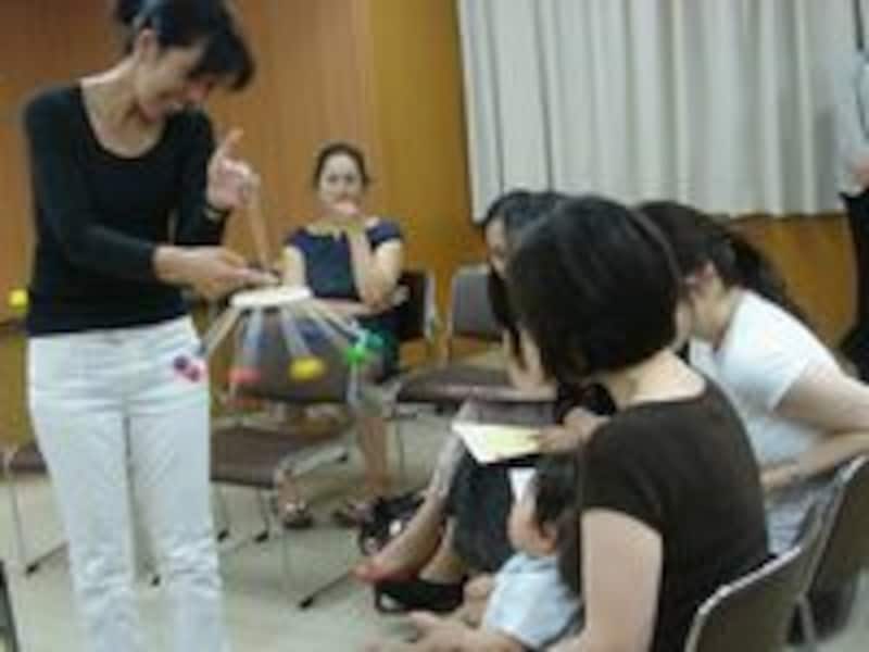赤ちゃんの目の前で人の手で回せるメリーを見せる「孫育て上手」編集長の棒田明子さん