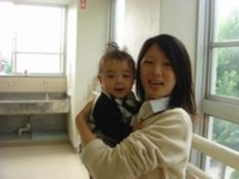 廊下で赤ちゃんを見つけて、さっそく抱っこする高校生。