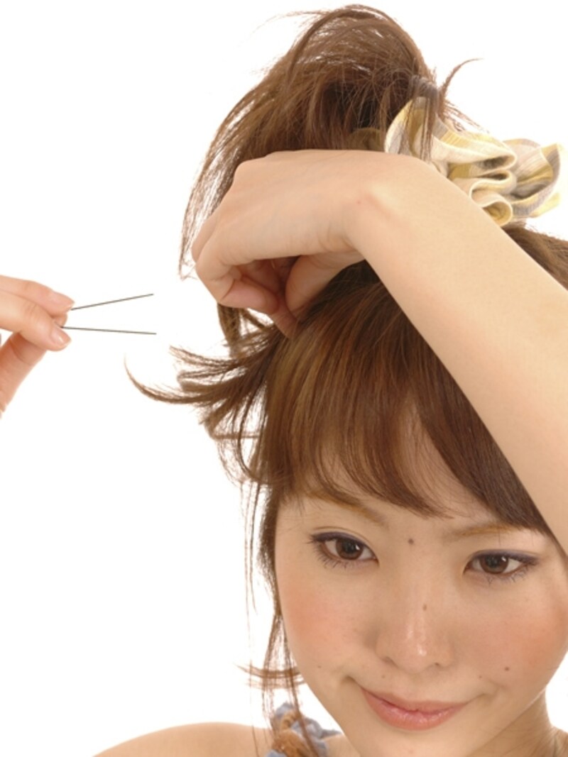 逆毛を潰さないように毛先付近を持ちピンで固定