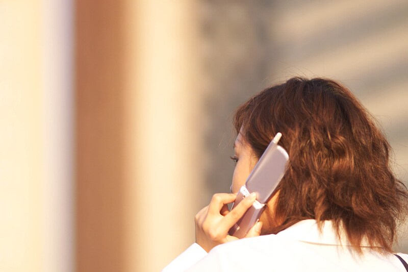 電話で問い合わせする女性