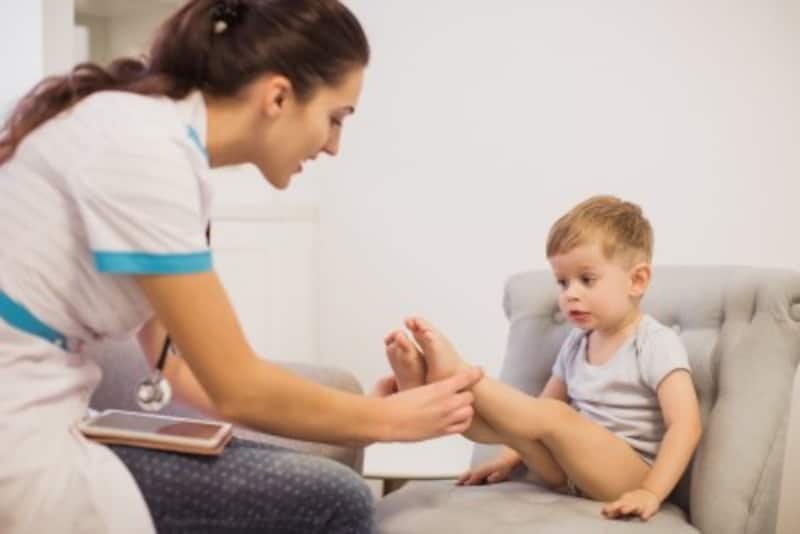 男児の足を診察する医師
