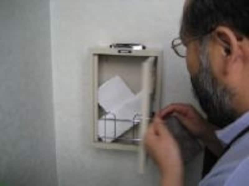 院長直行便から投書を取り出す院長