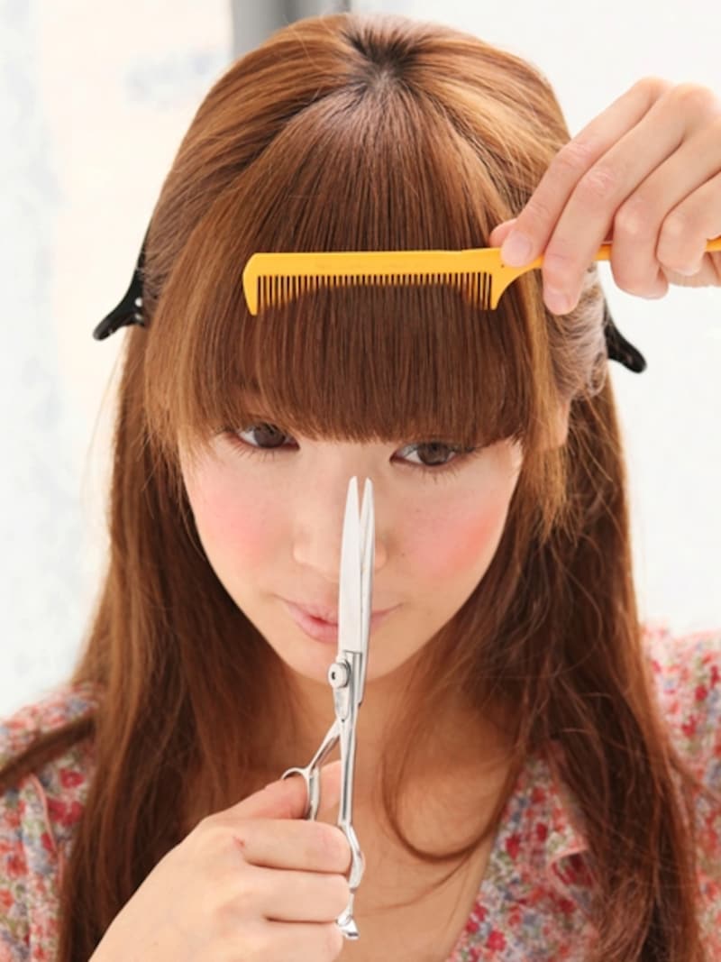 前髪にコームを通して毛先をカット