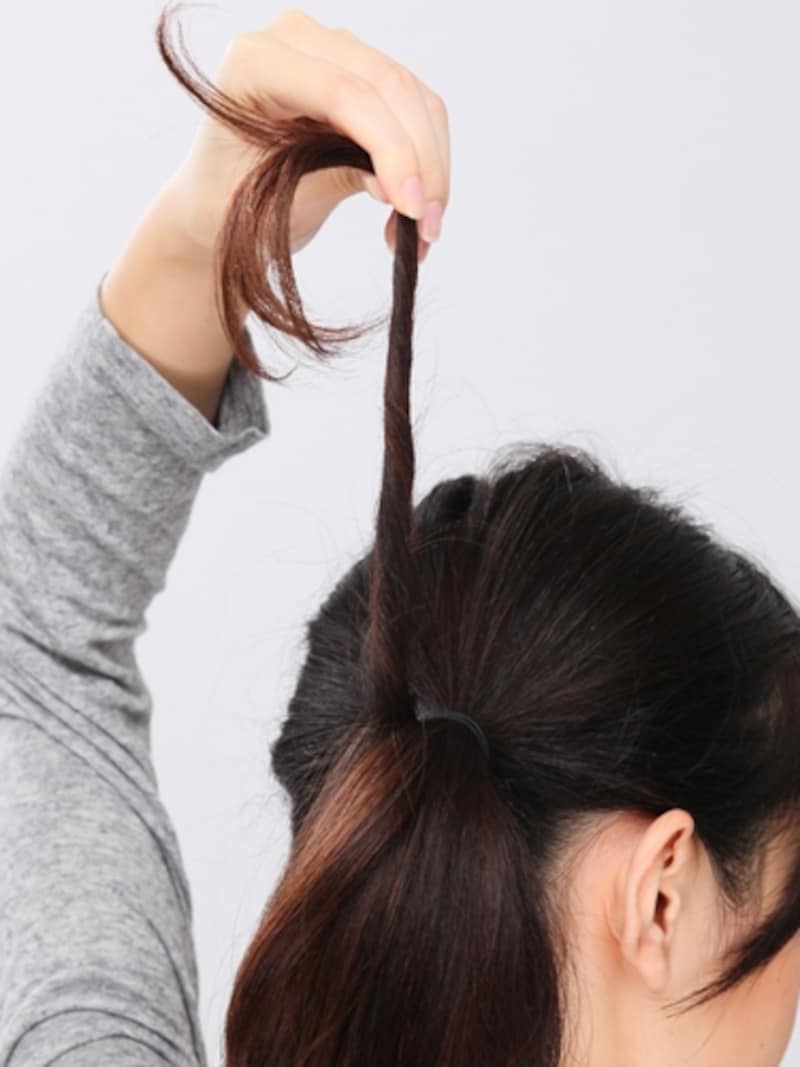 3. 毛束を上に引き上げてしっかりとねじる。