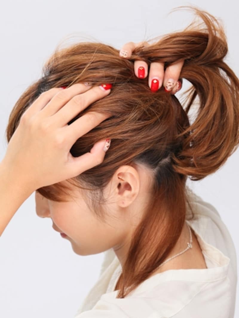 手ぐしでポニーテールを整える