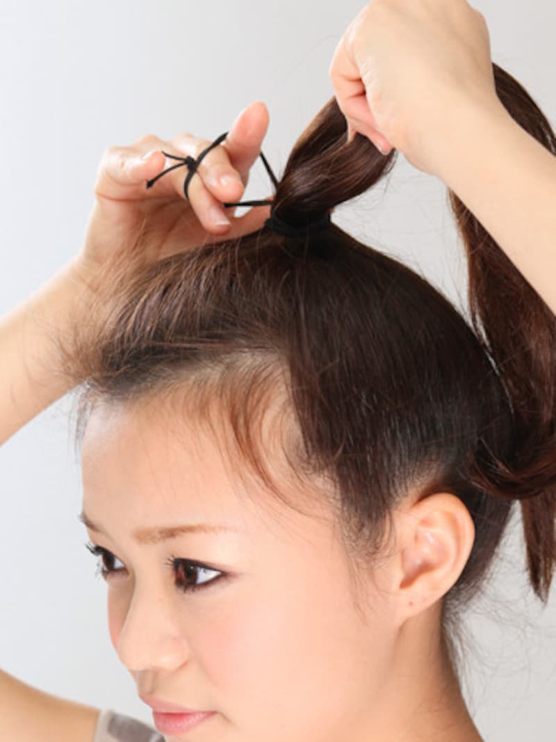 トップで髪全体をひとつに結ぶ