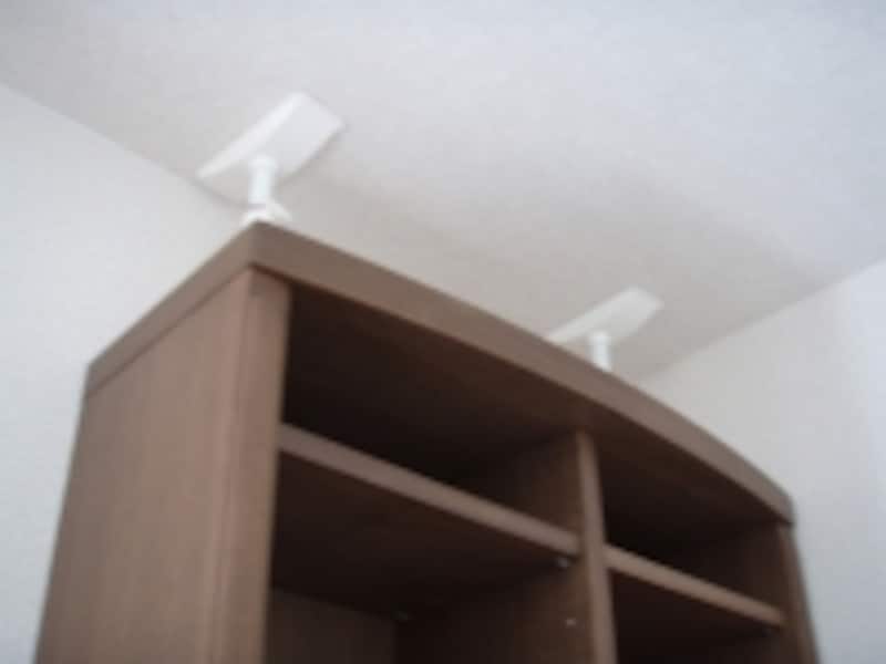 【写真Ａ】背の高い本棚に突っ張り棒を使用した例。本棚にけられて突っ張り棒はほとんど目立たない。
