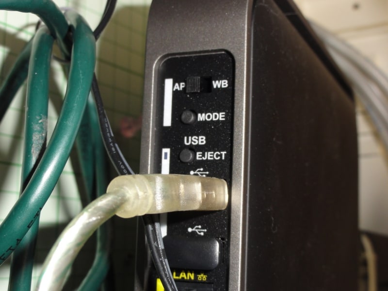 親機にあるUSB端子にプリンタを接続する。一番上がUSB端子。下のケーブルは、ほかのパソコンとつながっているLANケーブル。