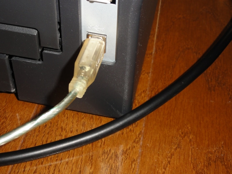 親機にあるUSB端子にプリンタを接続する。一番上がUSB端子。下のケーブルは、ほかのパソコンとつながっているLANケーブル。