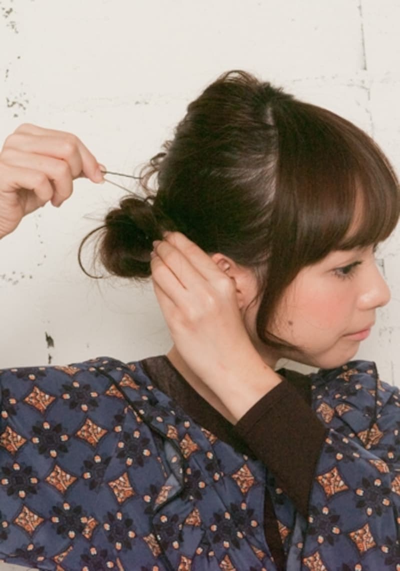 まとめた毛束を片方の手でしっかりと固定してからピニングする