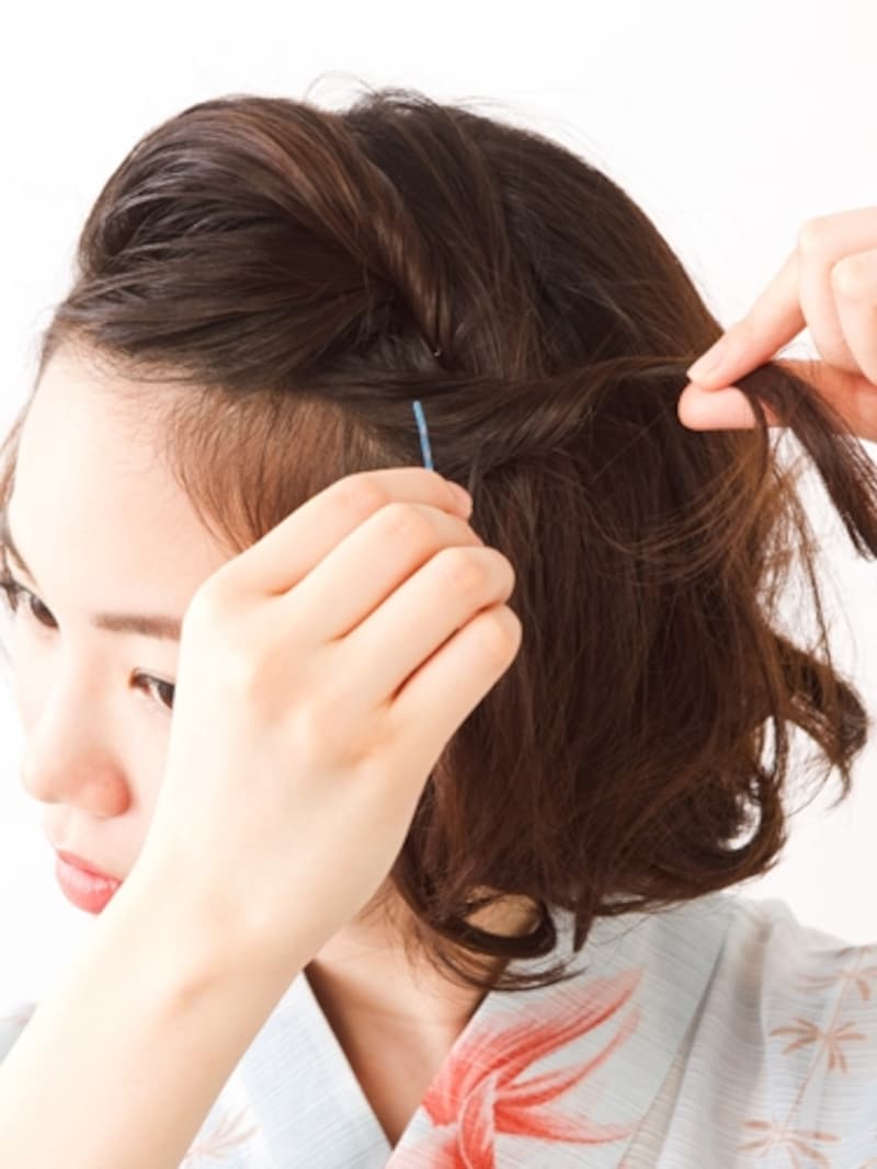 こめかみの毛束をねじってアメピンで固定