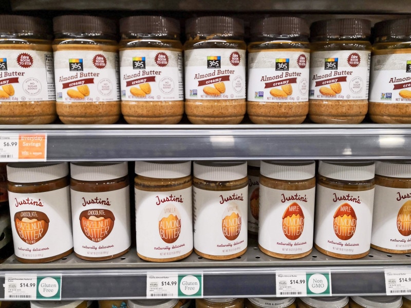 「365」の砂糖未使用ピーナッツバター(上段)。人気ブランド「ジャスティンズ」(下段)の約半額で購入できる