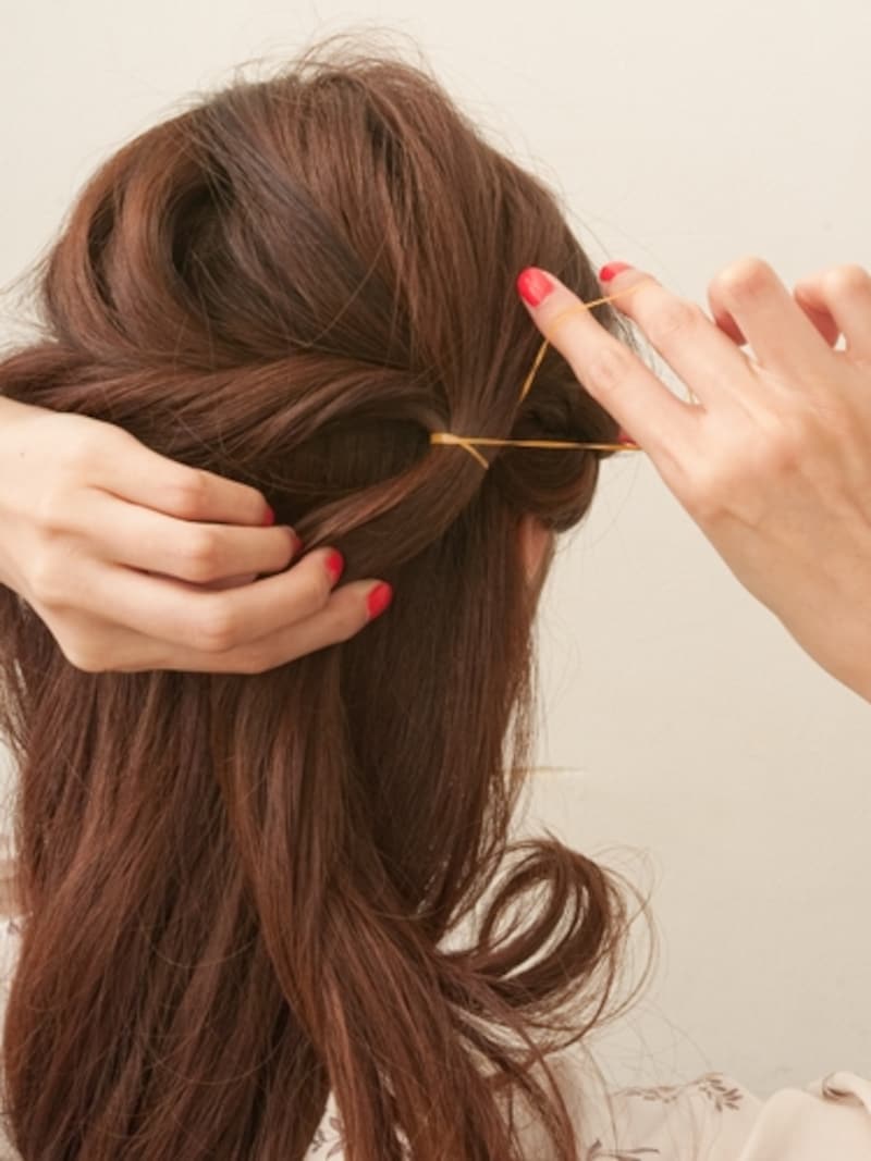 編みこみの仮ゴムをはずしツイストの束と合わせて一緒に結ぶ