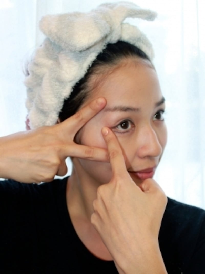 チョキの手でしわを伸ばし、保湿クリームを目尻に塗っていきます