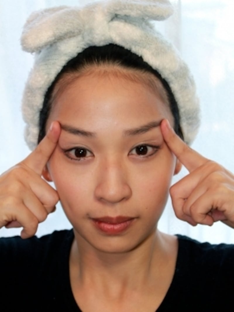 こめかみを斜め上に引き上げます