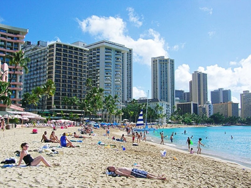 ピンク(ロイヤル・ハワイアン)、ブルー(アウトリガー)、白(サーフライダー)とホテル宿泊者専用のパラソルが並ぶカハロア&ウルコウ・ビーチ