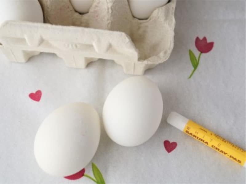 ゆで卵に白いクレヨンで絵や文字を書きます。