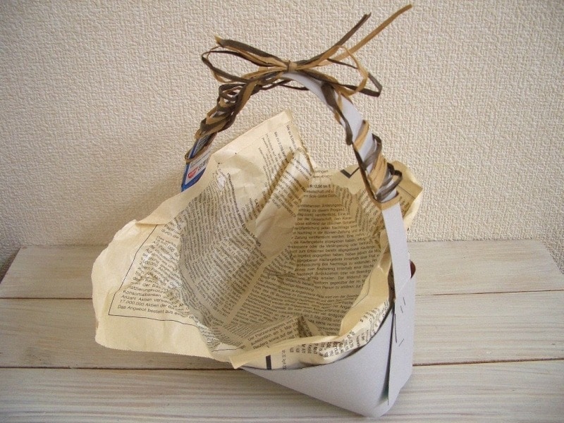 内側に包装紙を敷き、持ち手にリボンを巻く