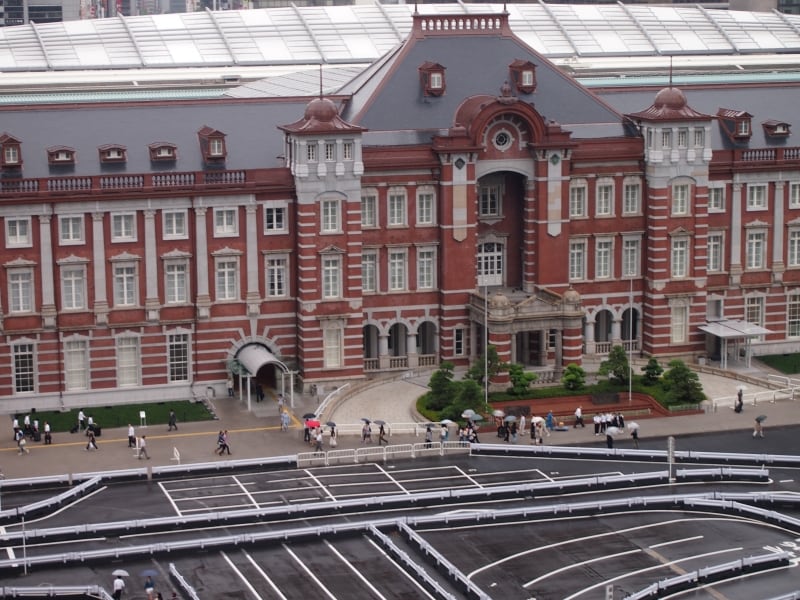 小雨のぱらつく日で、傘をさしている人が小さく見える