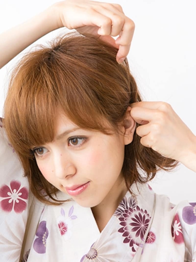 トップから耳上の髪をねじり、毛束を引き出す