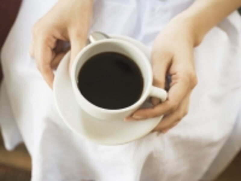 コーヒーを見つめる女性