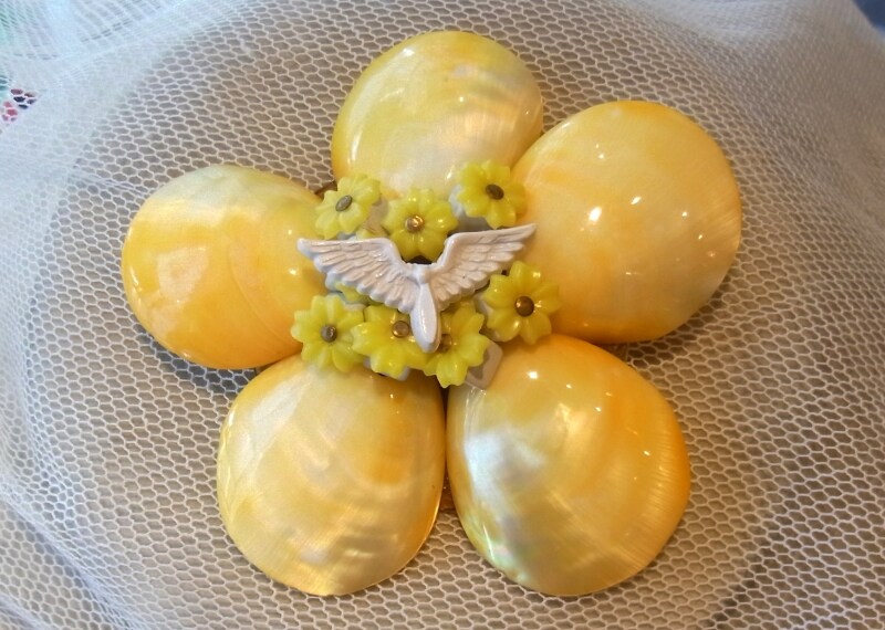 イエローの花々に白い羽根がポイントに