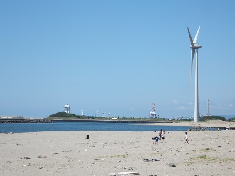 海水浴客と風力発電。砂浜に林立する風力発電の景色は目を奪う。