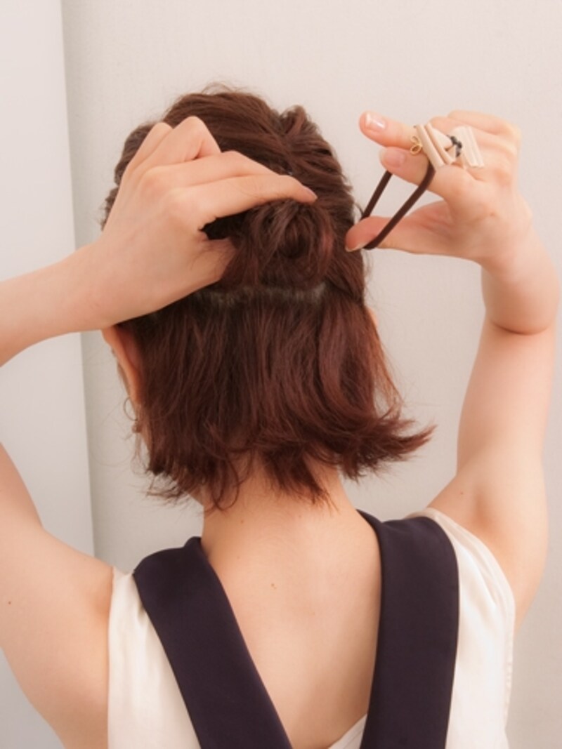 結び目を片手でしっかりと固定してから飾りゴムをつける