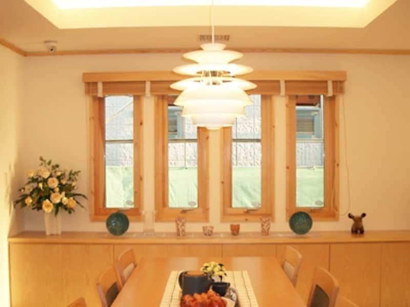 ルイスポールセン社のペンダントライトと間接照明に照らされたダイニング。シンプルな作りのテーブルとナチュラルな色合いが料理を引き立てる（スウェーデンハウス）