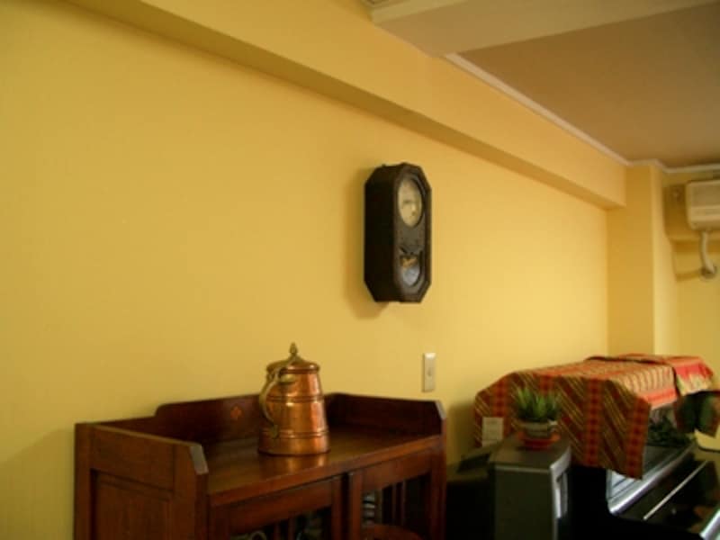 下がり壁を撤去し、壁紙の上からペンキで卵の黄身色に塗装したリビングの壁面。