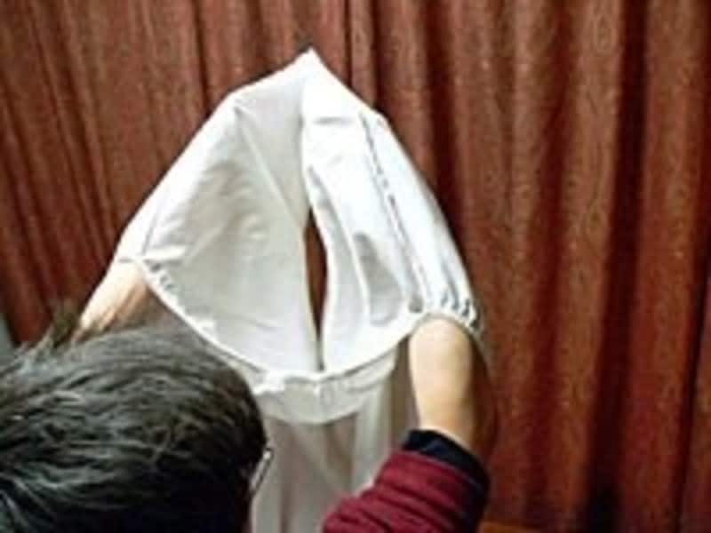 ボックスシーツのたたみ方手順2：両方の隅をくっつけて、右側で左側を覆うように