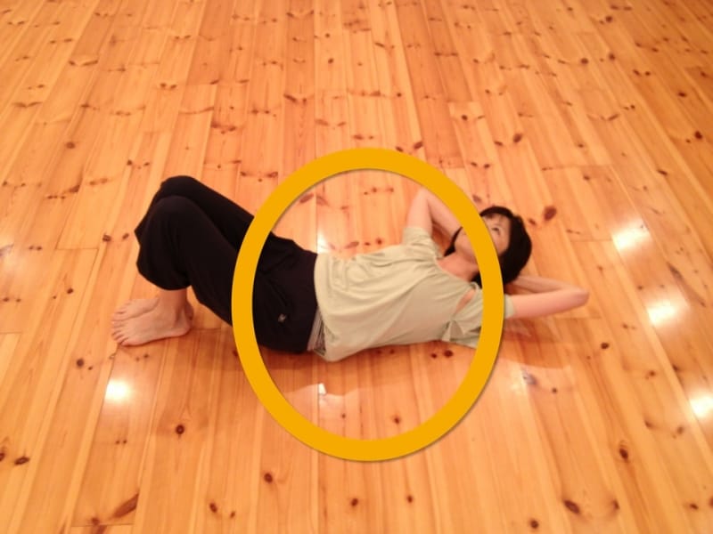 床でカラダを滑らせ、わき腹ストレッチ