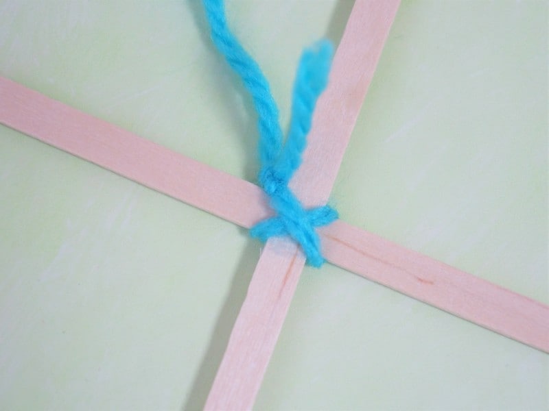 ゴッドアイ作り方　十字に掛けた毛糸をしっかりと縛ります。