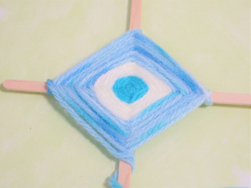 ゴッドアイ作り方　毛糸の色を変えながら巻きつけて行きます。